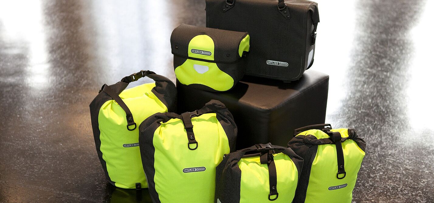 Komplett reflektierende Taschenset mit Back- und Frontrollern und Lenkertasche in gelb, Fahrradaktentasche in schwarz. Komplett reflektierende Taschenset mit Back- und Frontrollern und Lenkertasche in gelb, Fahrradaktentasche in schwarz.